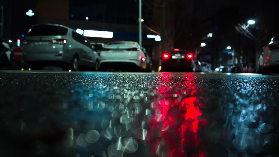 Car driving on a road in heavy rain, snow, and fog