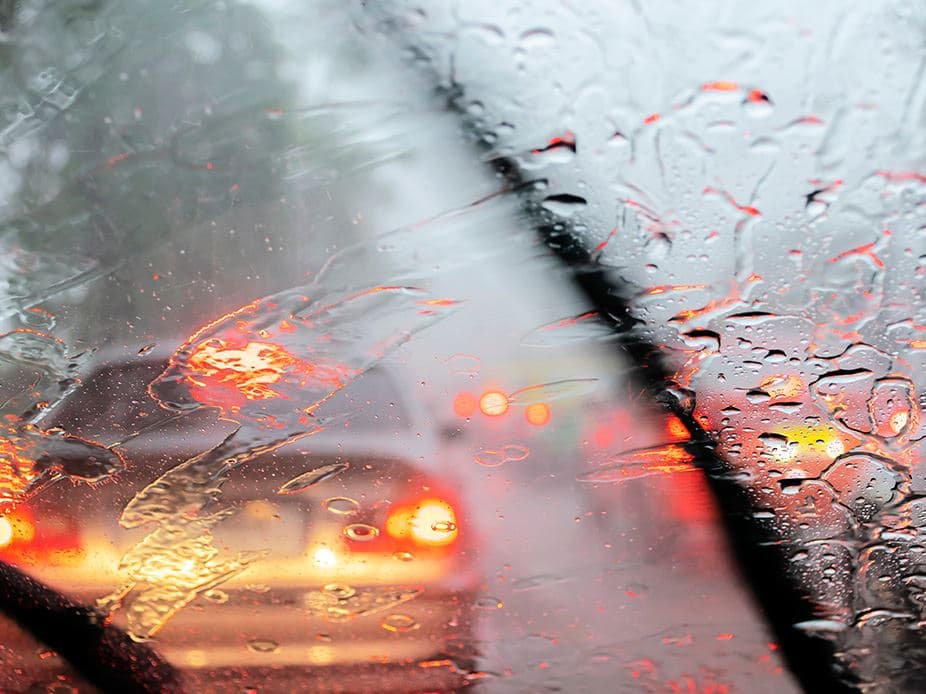 Car driving in heavy rain with windshield wipers on