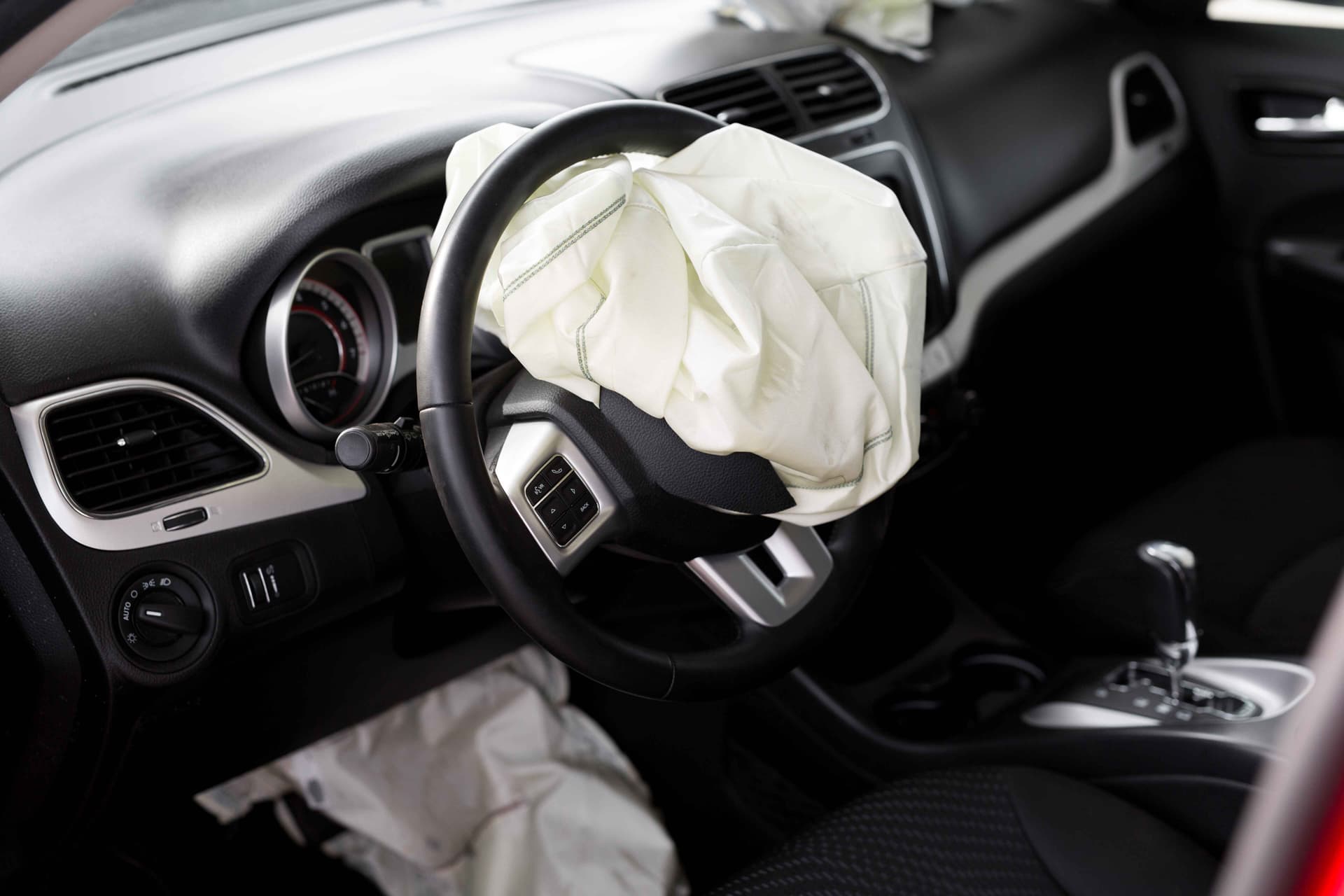 An image showing various airbags deploying in a car during a crash test.