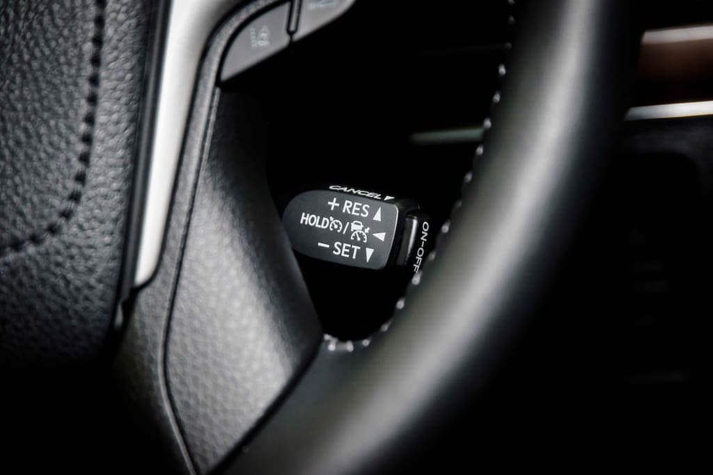 An image of a car dashboard showing the adaptive cruise control settings being adjusted.